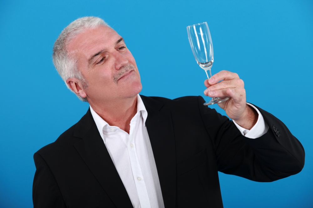 Grey-haired man holding champagne flute