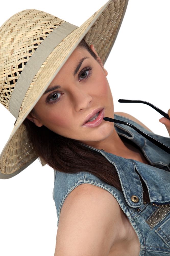 Flirtatious brunette wearing straw hat