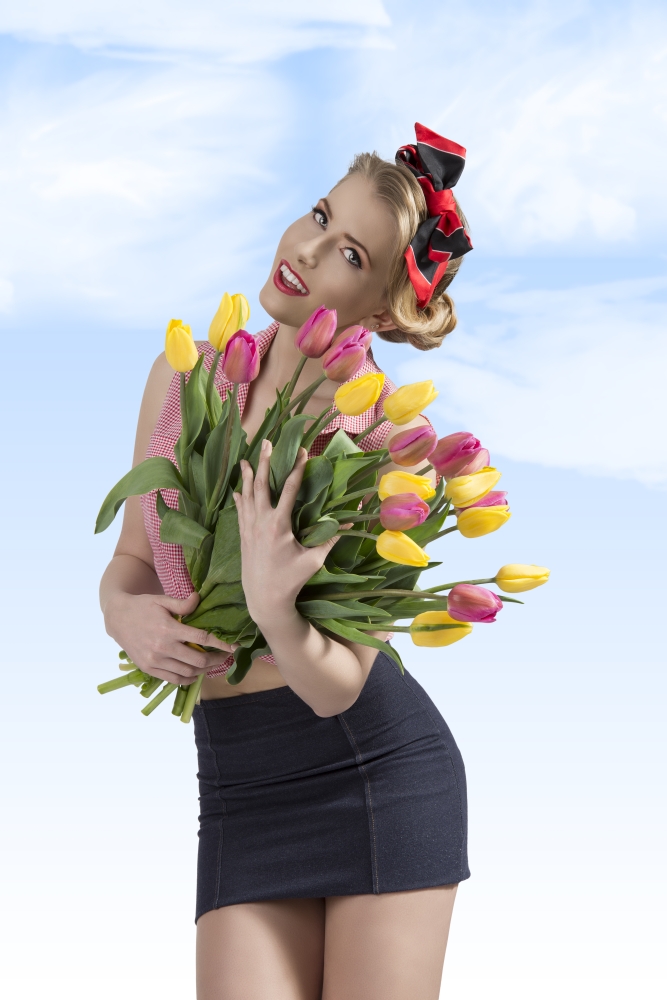 sensual pretty girl pin-up with blonde hair-style wearing sexy clothes and posing with coloured bouquet of tulips