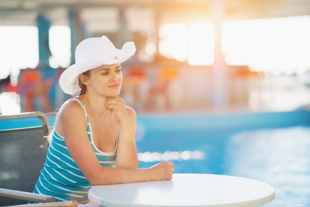 Portrait of dreaming woman at pool bar looking on copy space