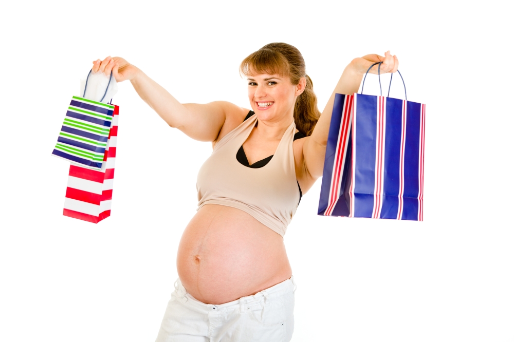 Smiling pregnant woman holding shopping bags in hands isolated on white&#xA;