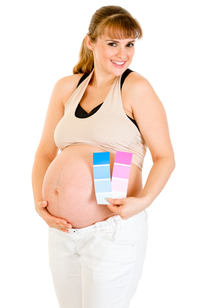 Happy beautiful pregnant woman holding color paint samples near her belly isolated on white&#xA;