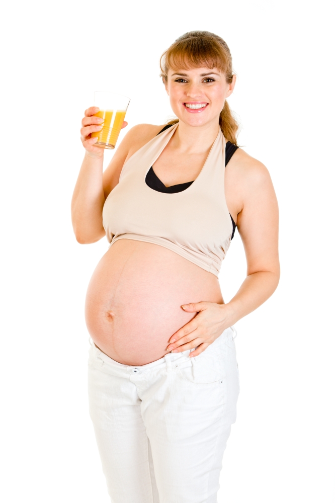 Smiling pregnant woman holding glass of juice in hand isolated on white&#xA;