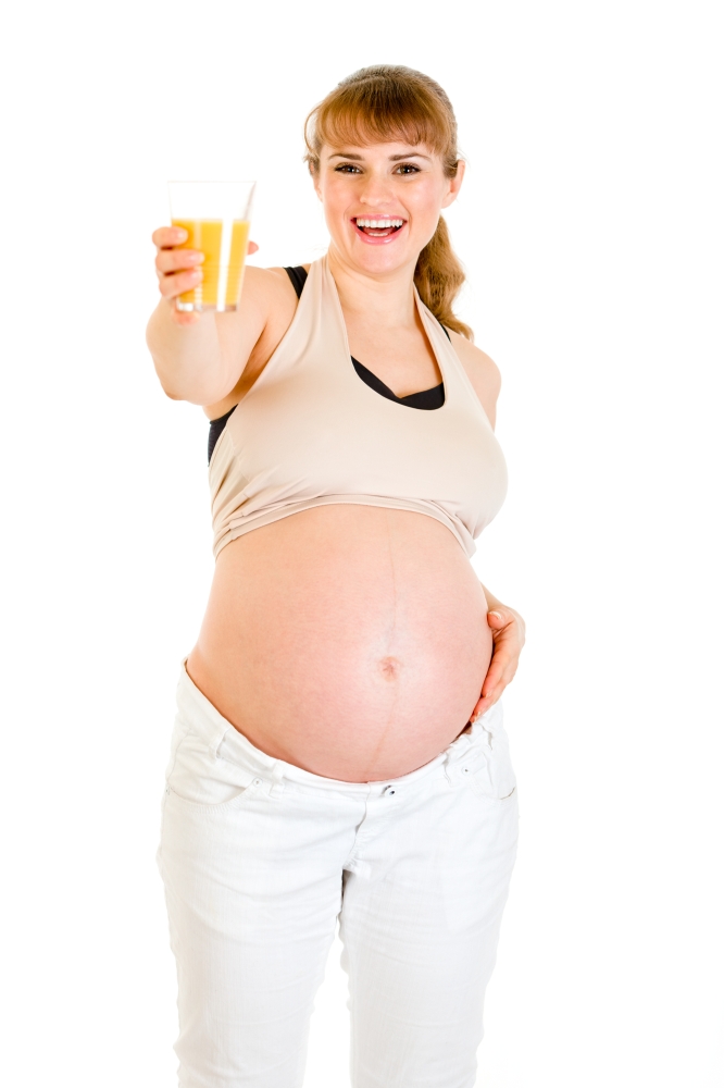 Happy pregnant woman holding glass of juice in hand isolated on white&#xA;