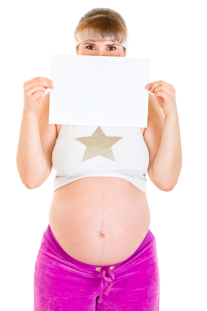 Pregnant woman holding empty white  paper in front of her face isolated on white. &#xA;