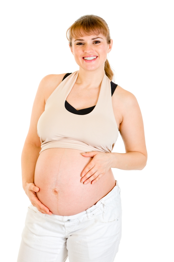 Smiling beautiful pregnant female holding her belly isolated on white background&#xA;