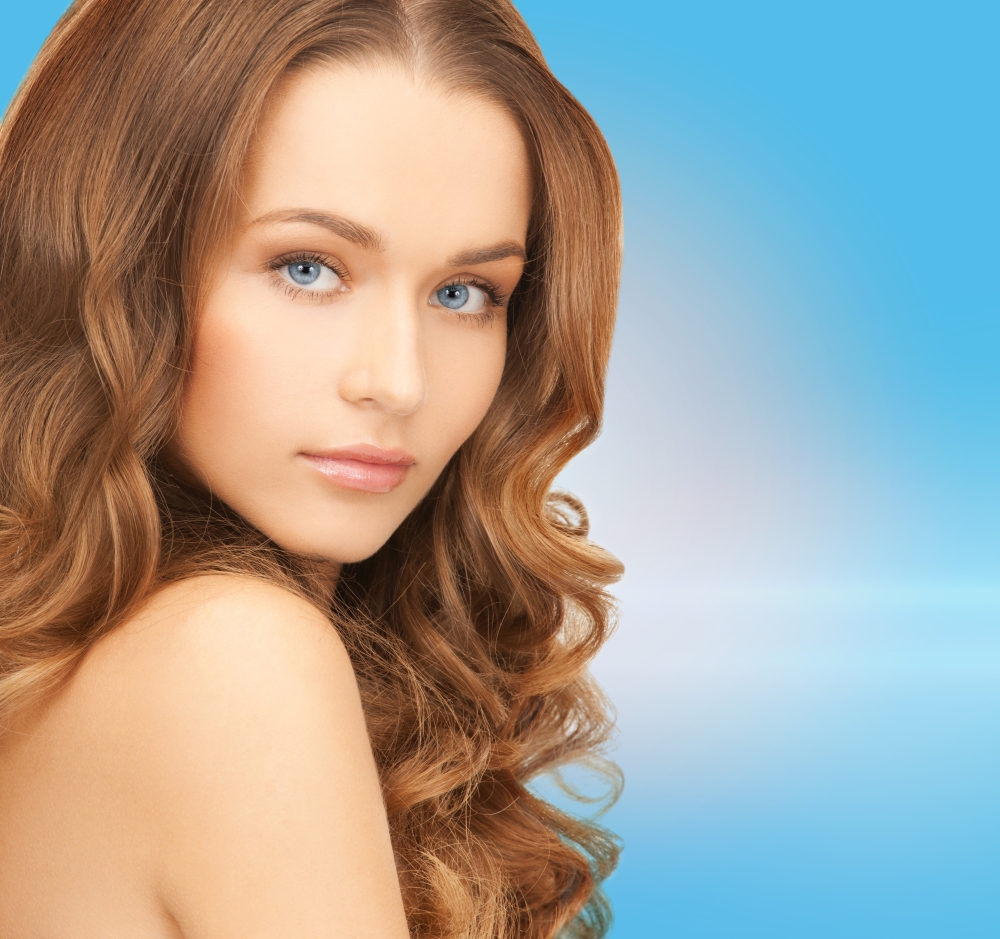 health and beauty concept - face of beautiful woman with long hair over blue background
