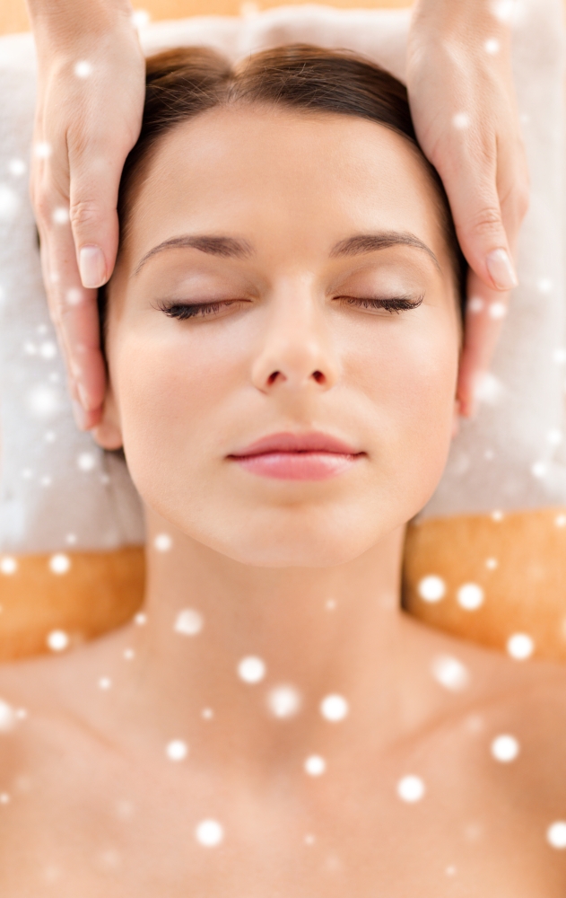 beauty, health, holidays, people and spa concept - beautiful woman in spa salon getting face or head massage