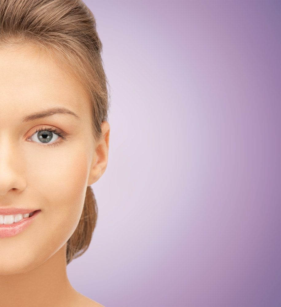beauty, people and health concept - close up of beautiful young woman half face over violet background