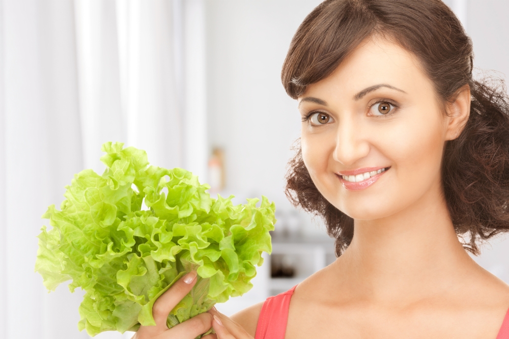 picture of happy woman with lettuce in kitchen