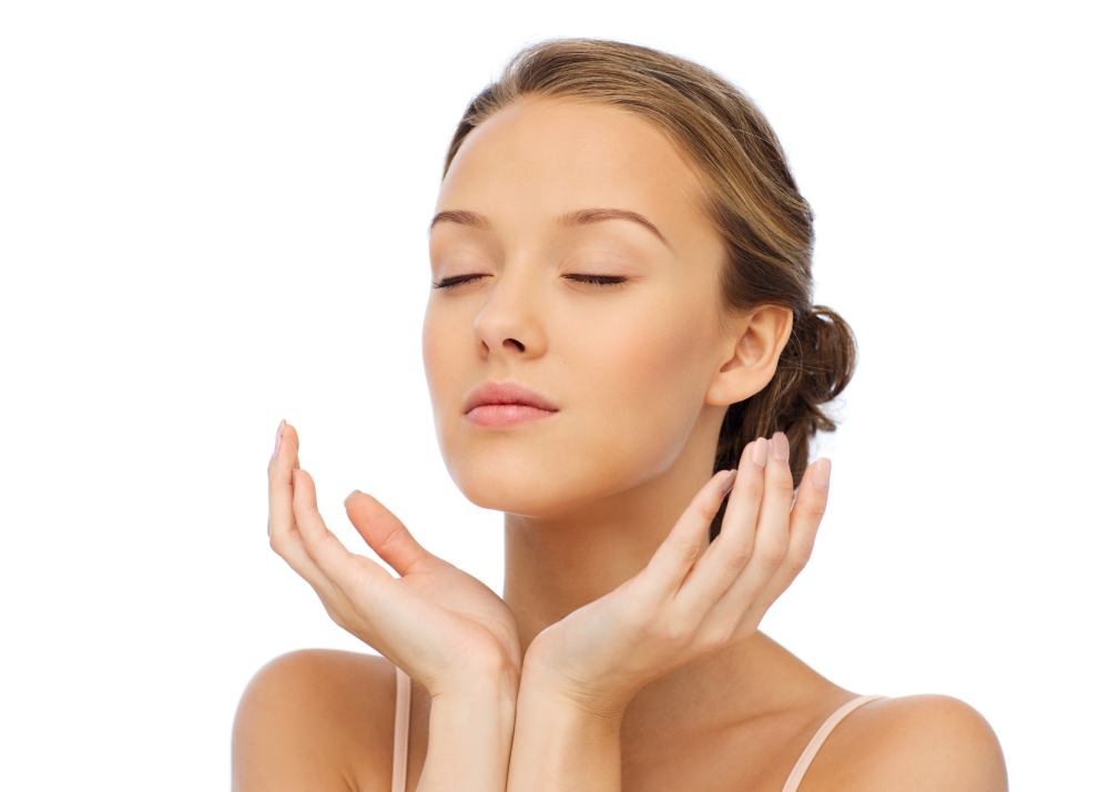 beauty, people, skincare and health concept - young woman face and hands