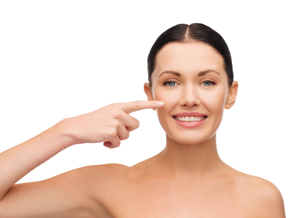 health, spa and beauty concept - clean face of beautiful young woman pointing to her cheek