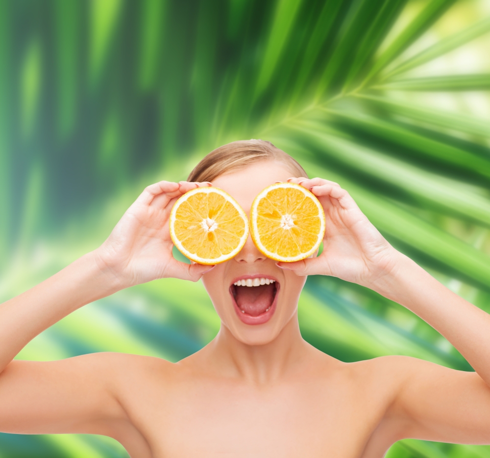 health, nutrition and beauty concept - clean face of beautiful young woman with orange slices