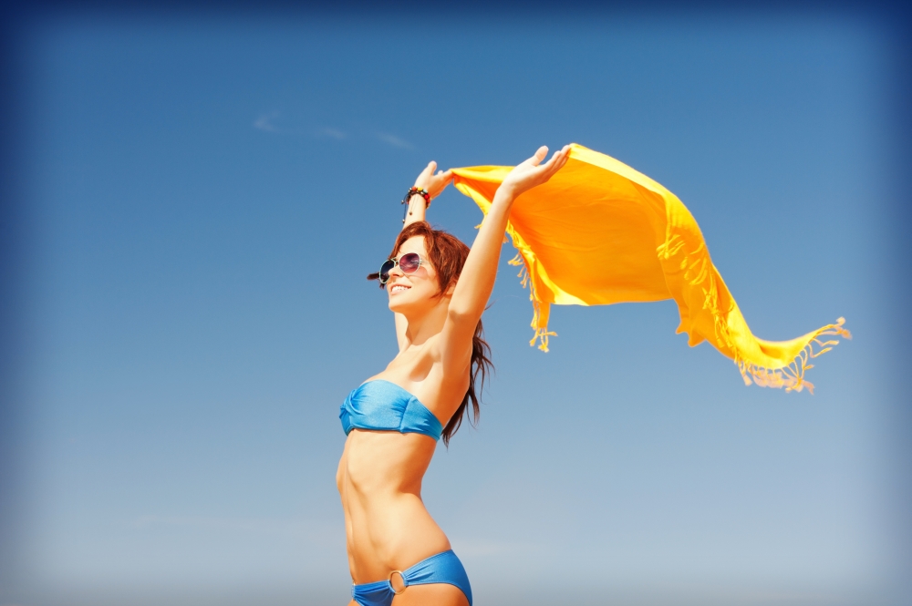 picture of happy woman with yellow sarong on the beach