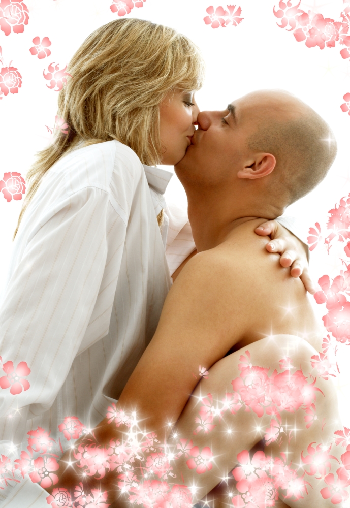 sweet couple playing and kissing in bedroom with flowers
