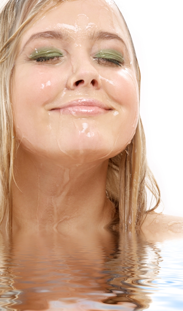 portrait of happy blond washing face in water