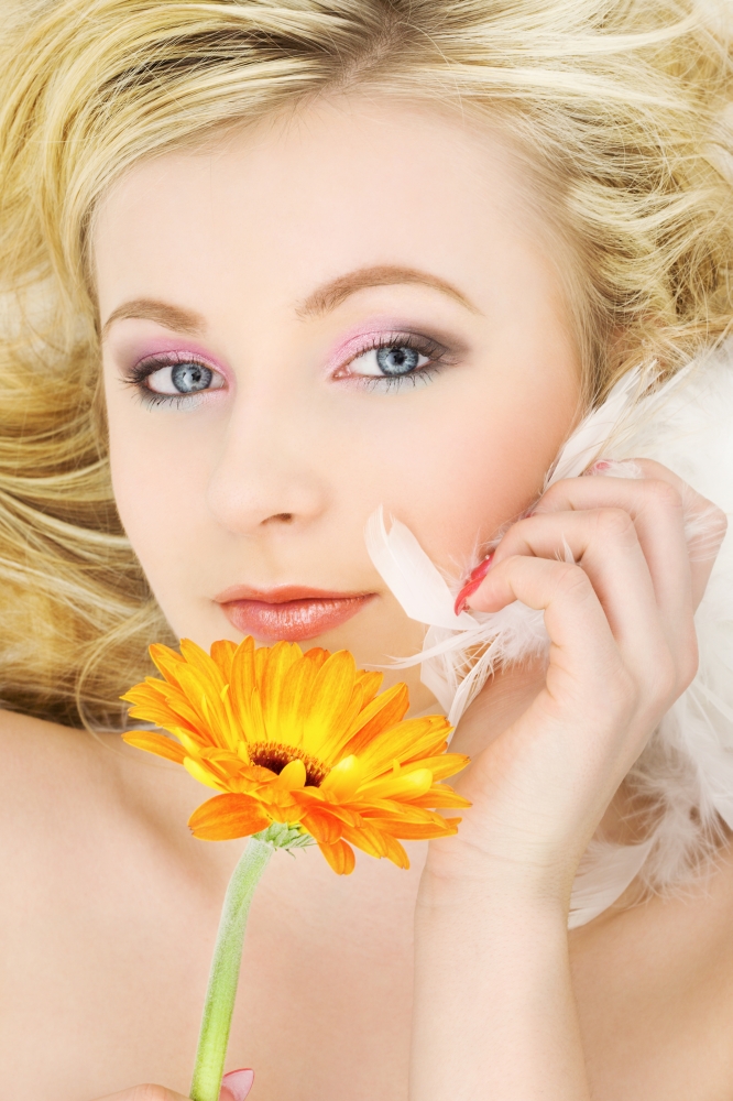 picture of blonde girl with flower and feathers