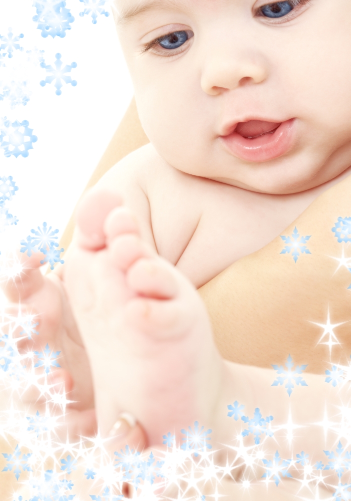 bright picture of adorable baby in mother hands with snowflakes