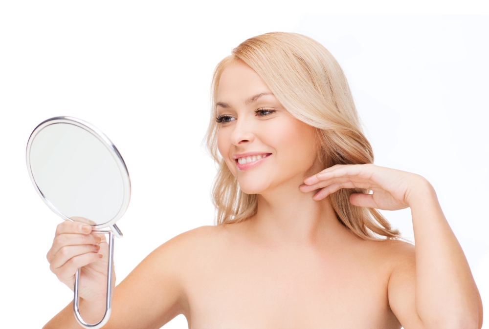 health, beauty and spa - smiling woman looking at mirror