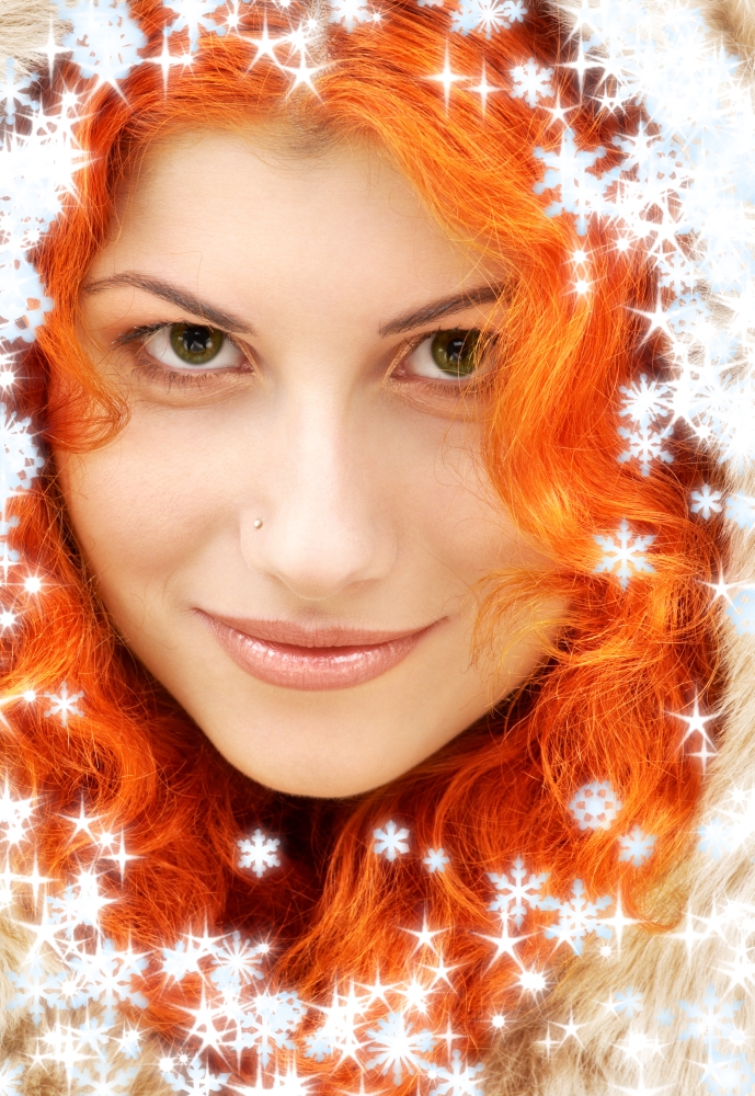 closeup portrait of lovely redhead in fur with snowflakes