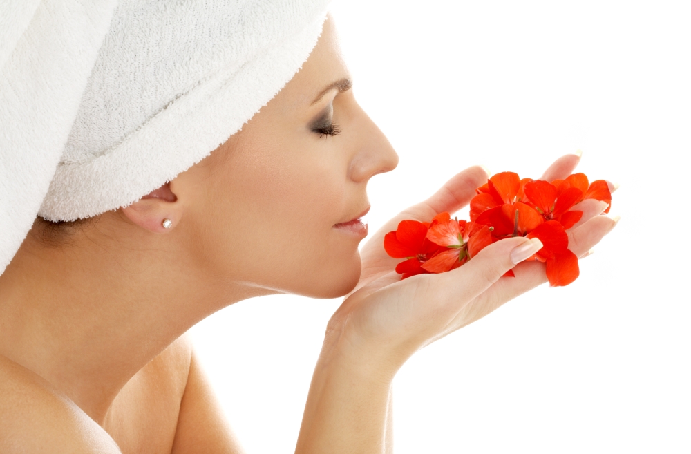 lovely woman smelling red flower petals