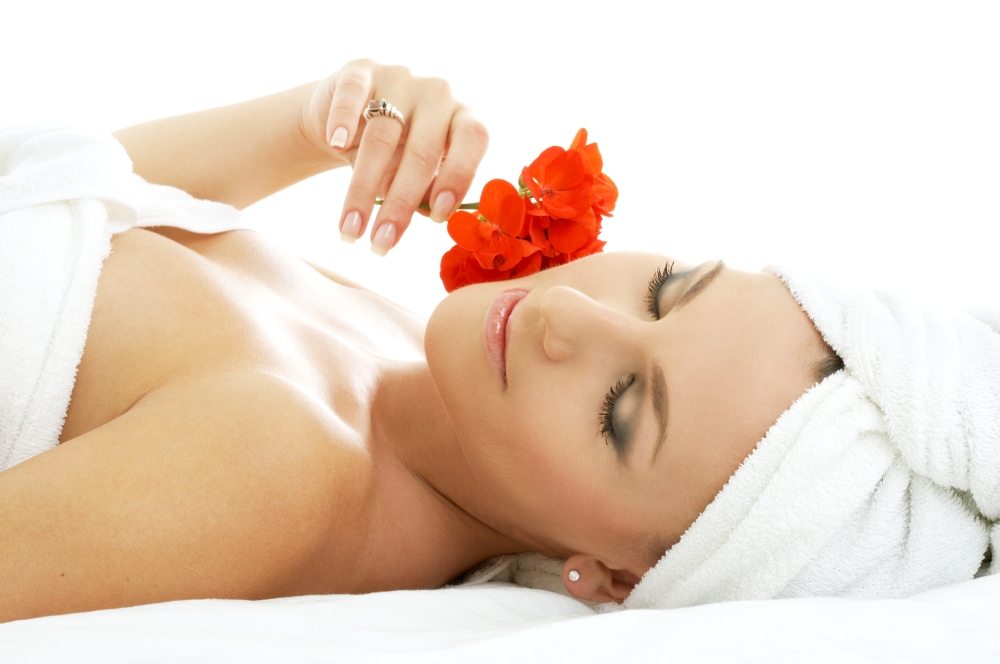 beautiful lady with red flower in spa salon