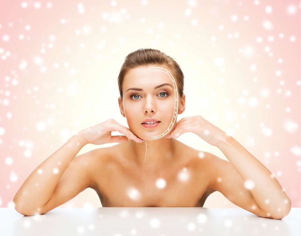 beauty, health, people and medicine concept - beautiful young woman with lines on face over pink snowy background