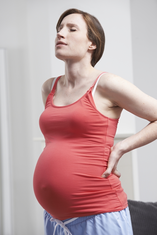 Close Up Of Pregnant Woman Exercising With Weights