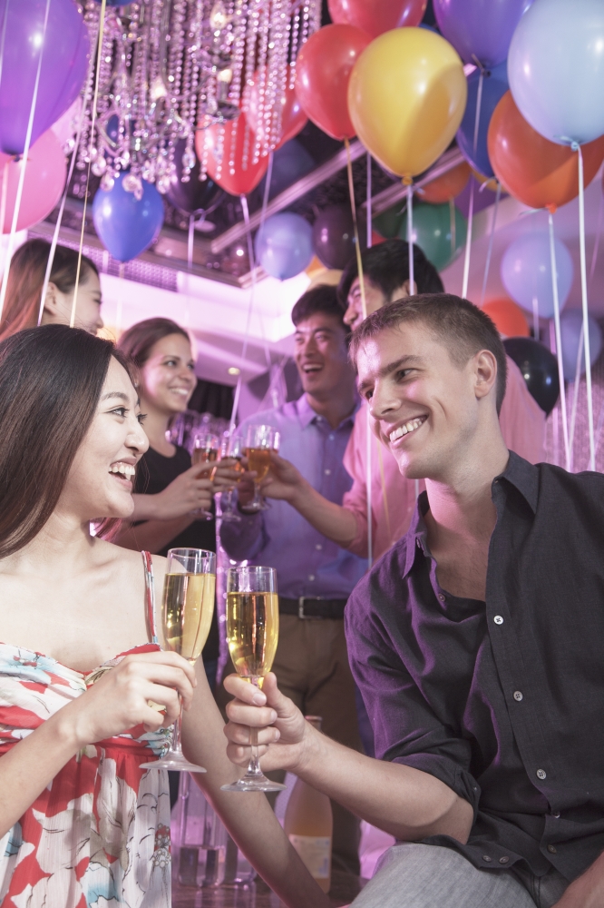 Group of friends celebrating, toasting with champagne, nightclub in Beijing