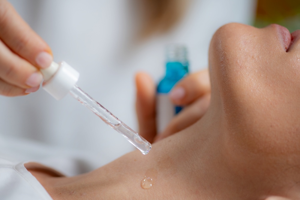 Cosmetician applies hyaluronic acid serum on woman&rsquo;s neck for targeted anti-aging benefits, enhancing skin elasticity  . Cosmetician applies hyaluronic acid serum on woman&rsquo;s neck for targeted anti-aging benefits, enhancing skin elasticity and firmness