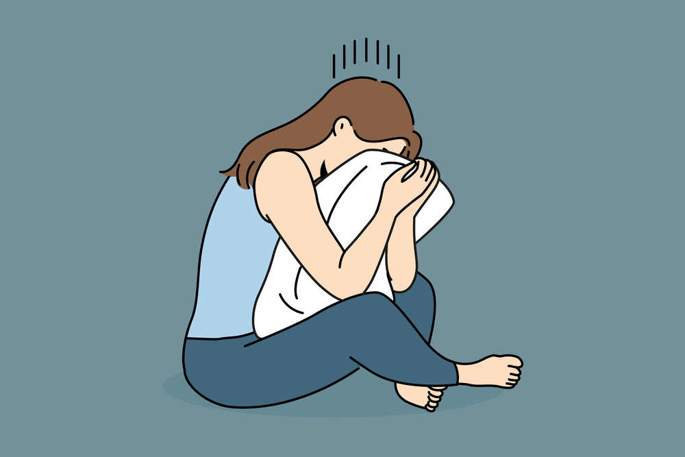 Crying woman sits hugging pillow and suffers because of problems in personal life or breaking up with boyfriend. Crying girl is experiencing psychological problems and needs help of psychotherapist. Crying woman sits hugging pillow and suffers because of breaking up with boyfriend