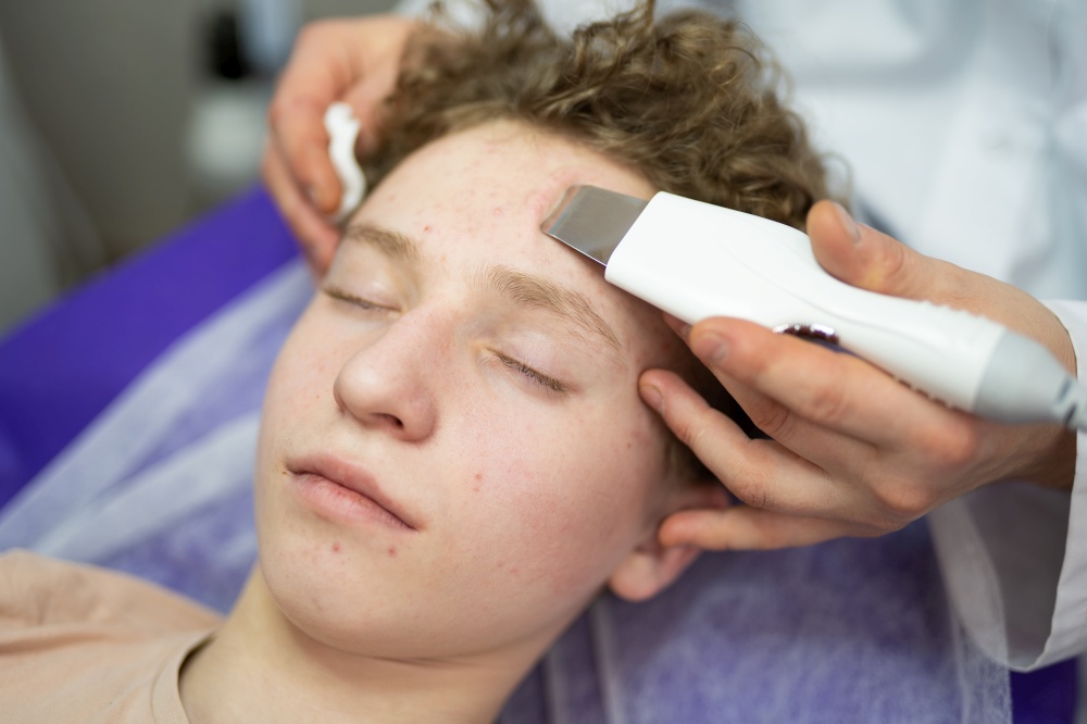 a cosmetologist doctor makes cosmetic procedures on the face of a young guy in a beauty salon
