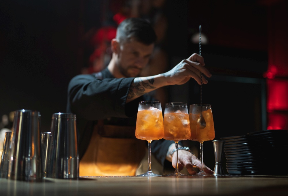 the bartender prepares a beautiful alcoholic cocktail at the bar counter