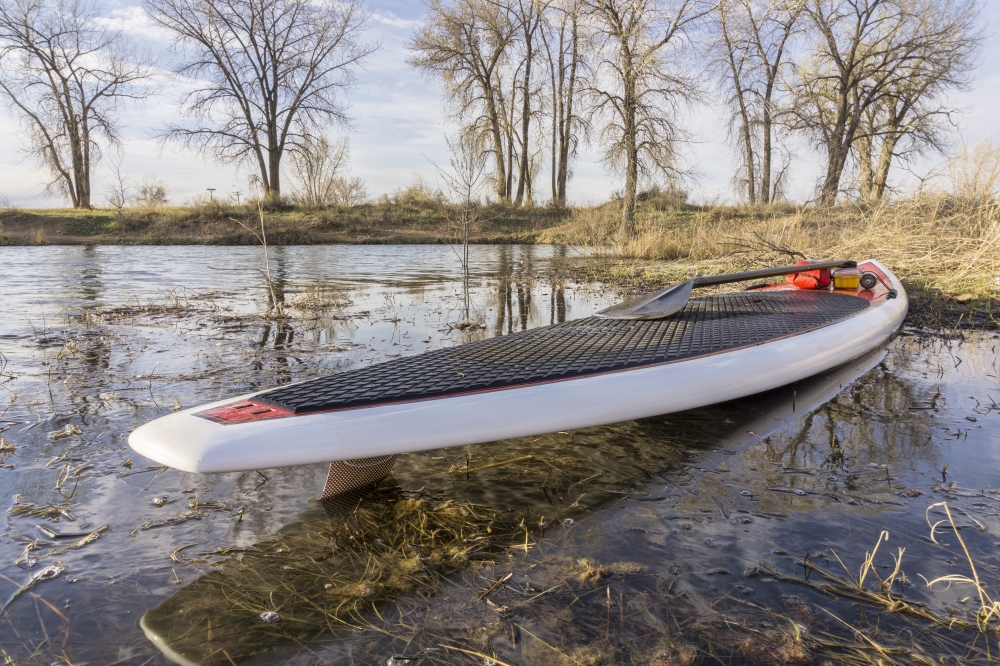 SUP paddleboard on a lake shore, spring time in Colorado