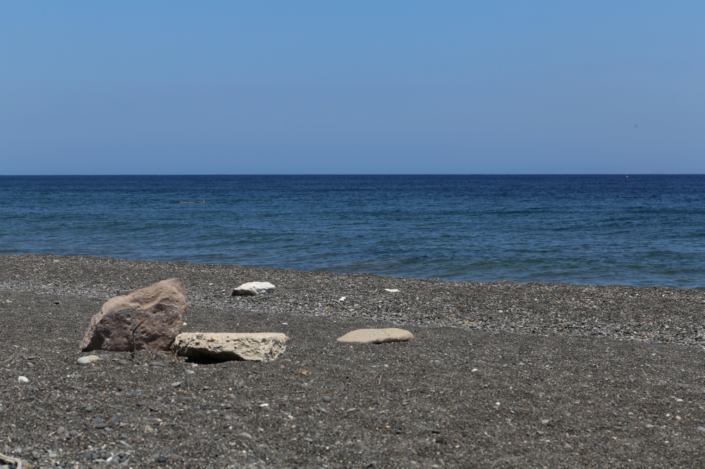 The Kamari beach with black volcanic stones at Santorini island, Greece