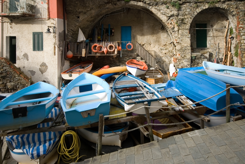 Small fishing boats stored on racks, in the quaint fishing village of Riomaggiore, Cinque Terre, Italy